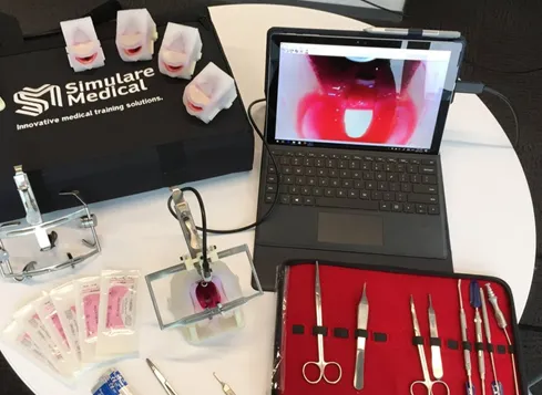 Simulare Medical cleft palate simulator models, surgical instruments and a laptop showing the palate view