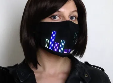 Woman wearing a black LED matrix face mask displaying a colourful equalizer pattern
