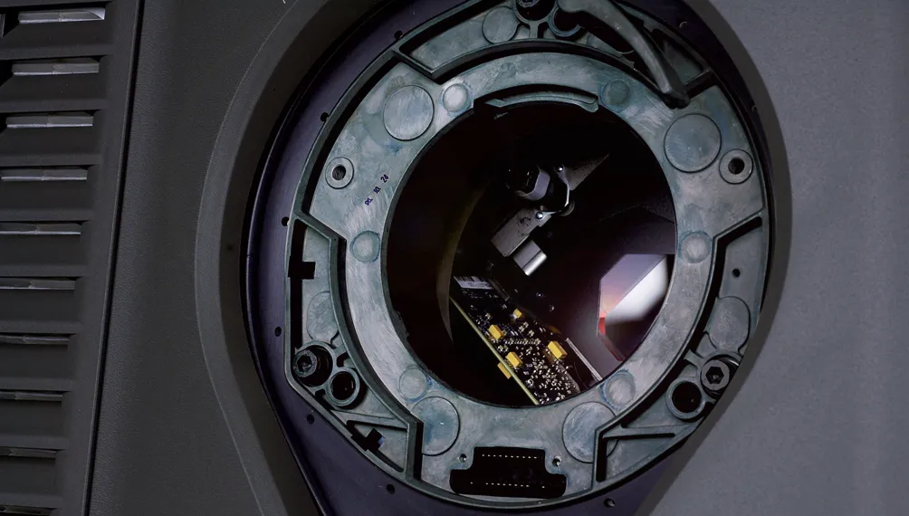 Open lens port on a Christie projector revealing internal circuit boards and optics