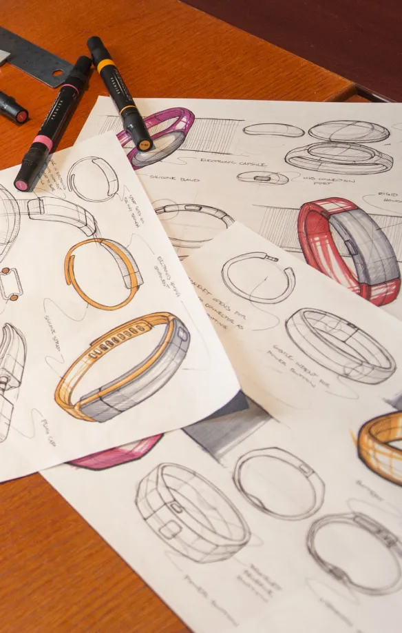 Marker sketches of fitness wristband concepts spread across a desk