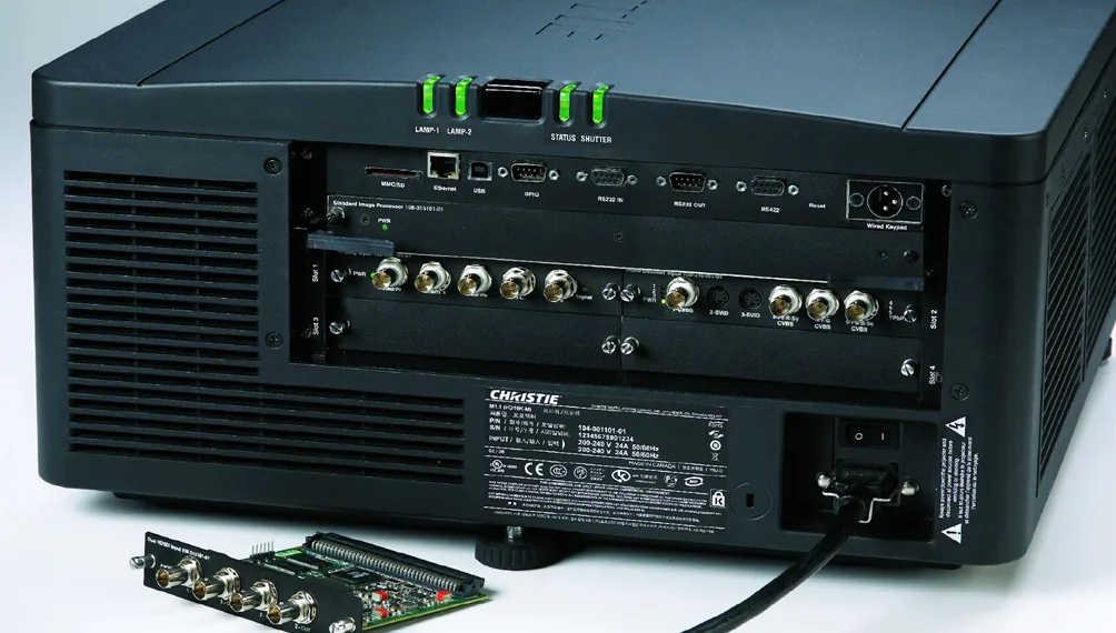 Rear panel of a Christie cinema projector with input connectors and a removable card