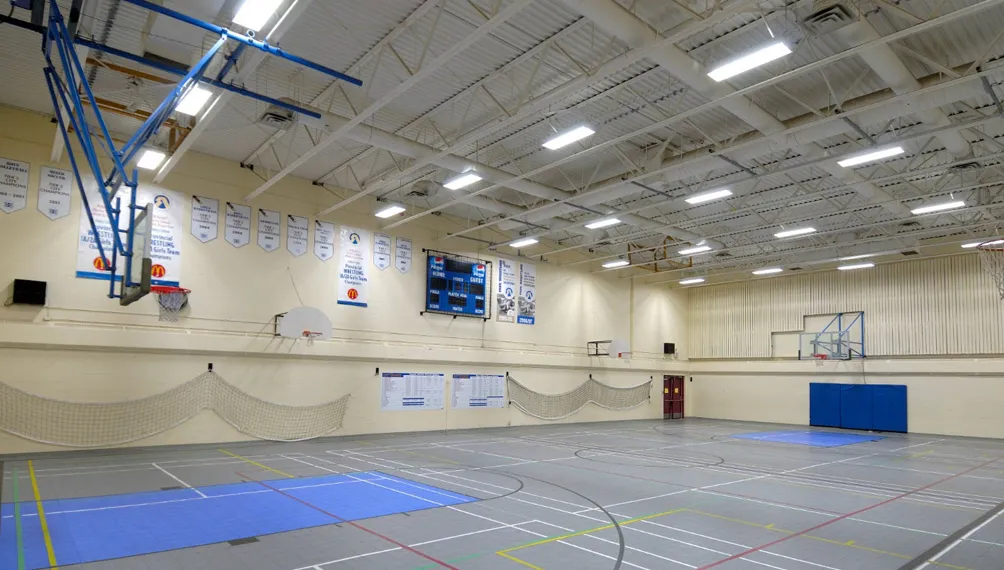 School gymnasium lit by rows of J2 Lights LED high-bay fixtures