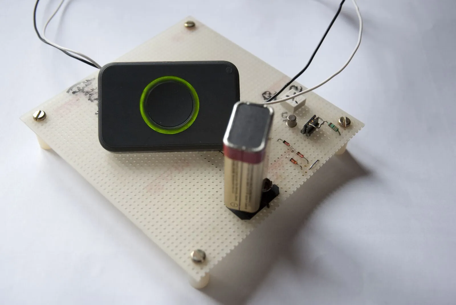 Breadboard prototype with a round button module, 9-volt battery and wired components