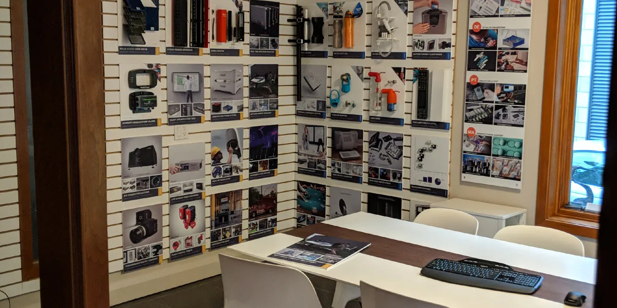 Design 1st boardroom seen from the doorway, with project boards on slatwall and a white meeting table