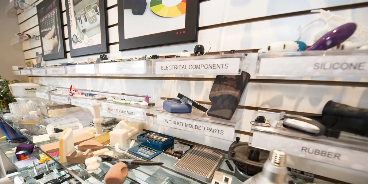 Old Design 1st boardroom shelves of sample parts labelled electrical components, silicone and rubber