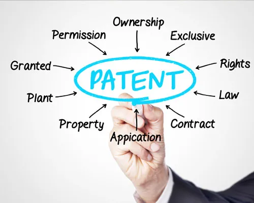 Hand circling the word patent surrounded by terms like ownership, rights, law and application
