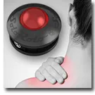 Handheld round massage device with red light pressed against a shoulder