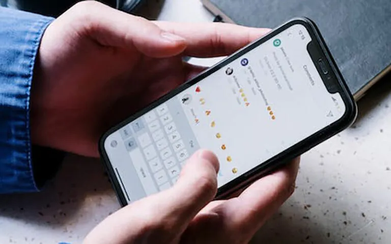 Person typing a comment with emoji on a smartphone