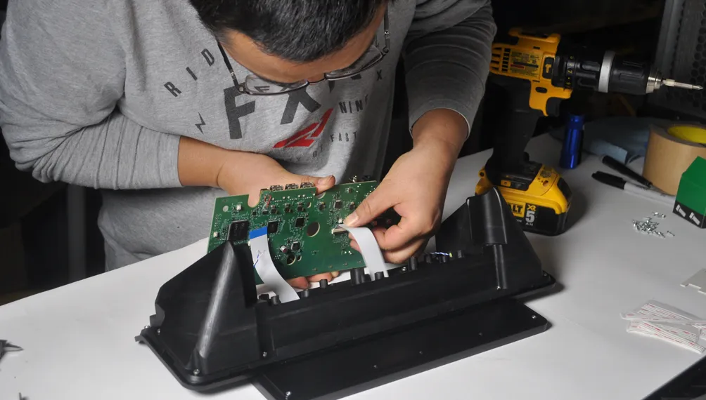 Engineer fitting a circuit board into the Cloud9 VoIP phone alpha prototype housing
