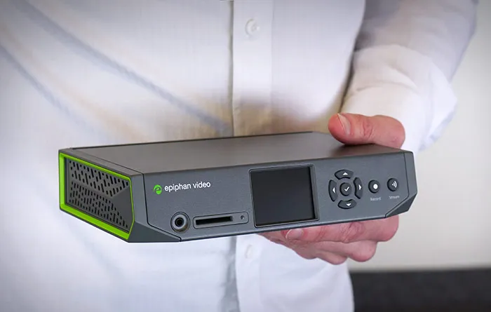 Epiphan Pearl Nano video encoder held in two hands, showing its screen and controls