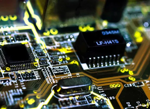 Close-up of a circuit board with a microchip, transformer and crystal oscillator