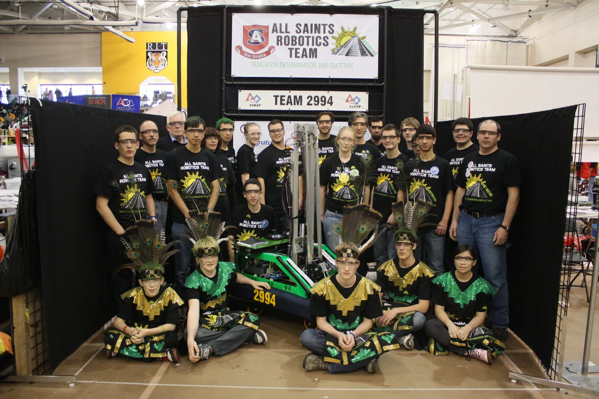All Saints Robotics Team 2994 posing with their green robot at the FIRST Robotics competition