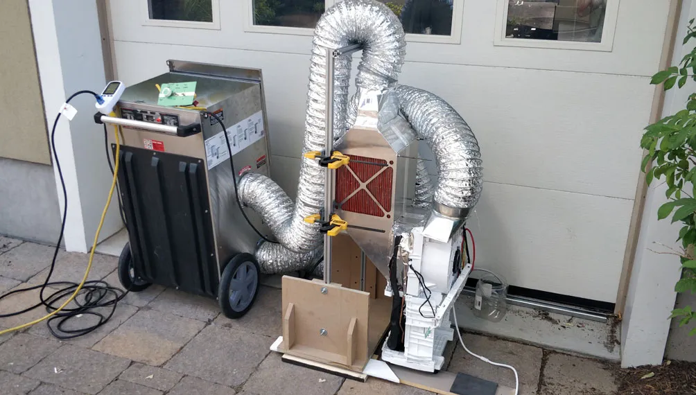 Molecule prototype dehumidifier test rig with flexible ducting outside a garage