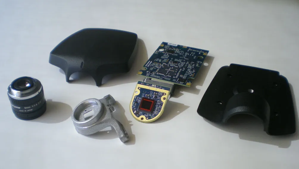 Lumenera camera prototype parts: lens, cast bracket, sensor board and enclosure halves