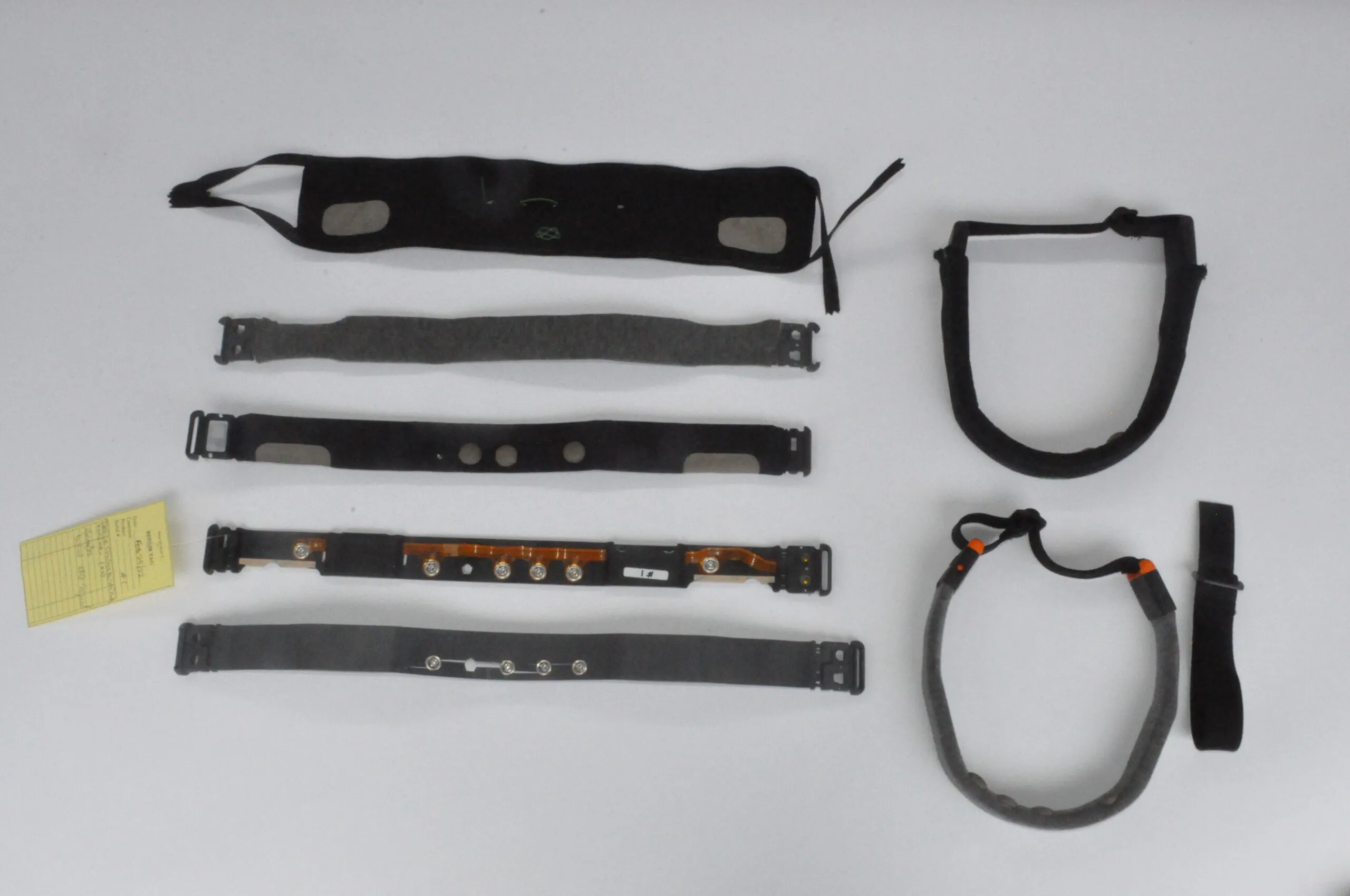 Neurovine headband prototype iterations laid out: fabric bands, electrode strips and flex circuit