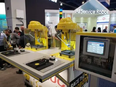 Yellow robotic arms in a Race the Robot demonstration at a CES 2020 booth