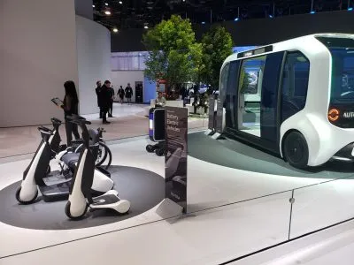 White autonomous electric shuttle and personal mobility scooters on display at CES 2020